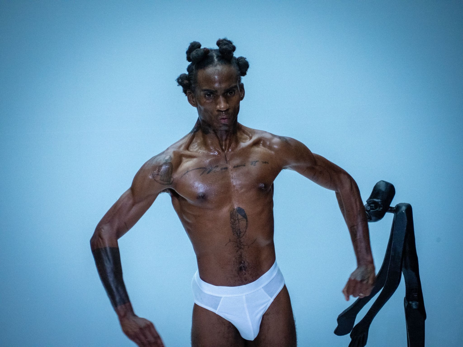 Mackenzy Bergile, en caleçon blanc, un air sérieux au visage, contracte ses muscles.