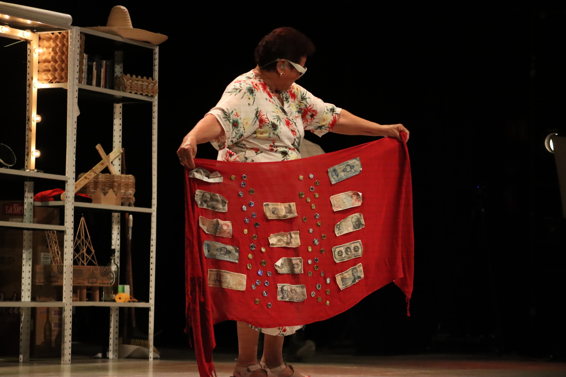Josefina Orlaineta holds up a red cloth with banknotes attached to it.