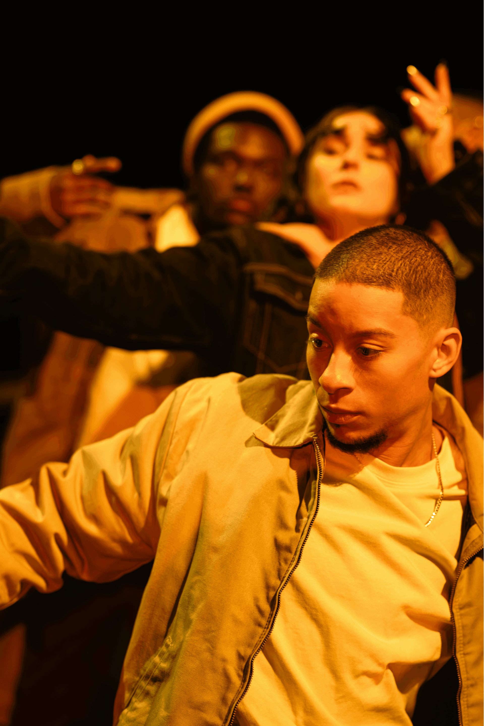 Close-up on a dancer, while a duet takes place in the background.