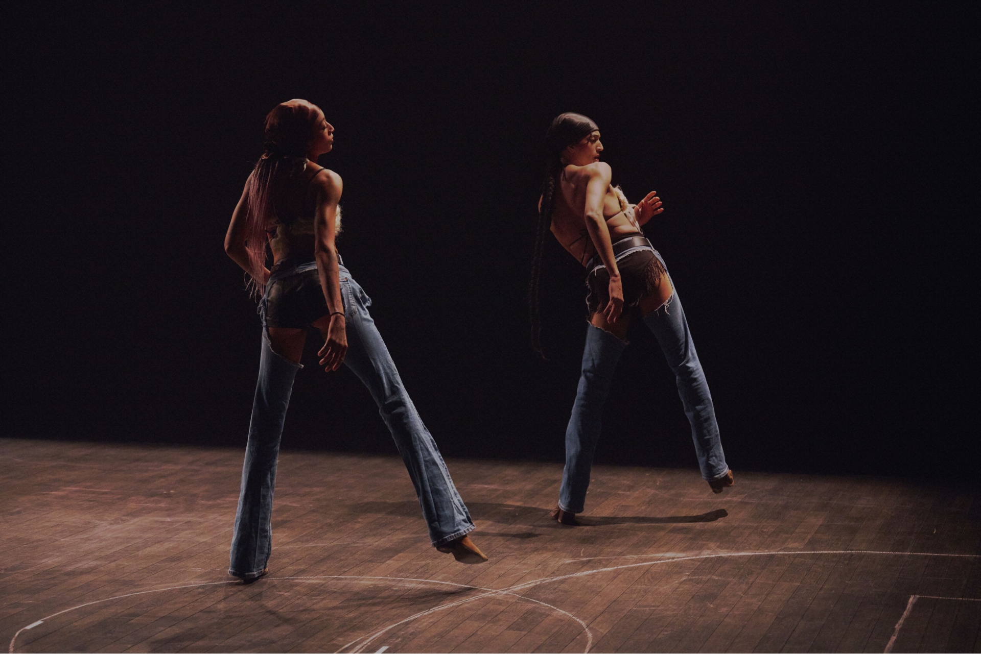 Satniée et Stacey danse un extrait de danse en ligne dans un espace sombre.