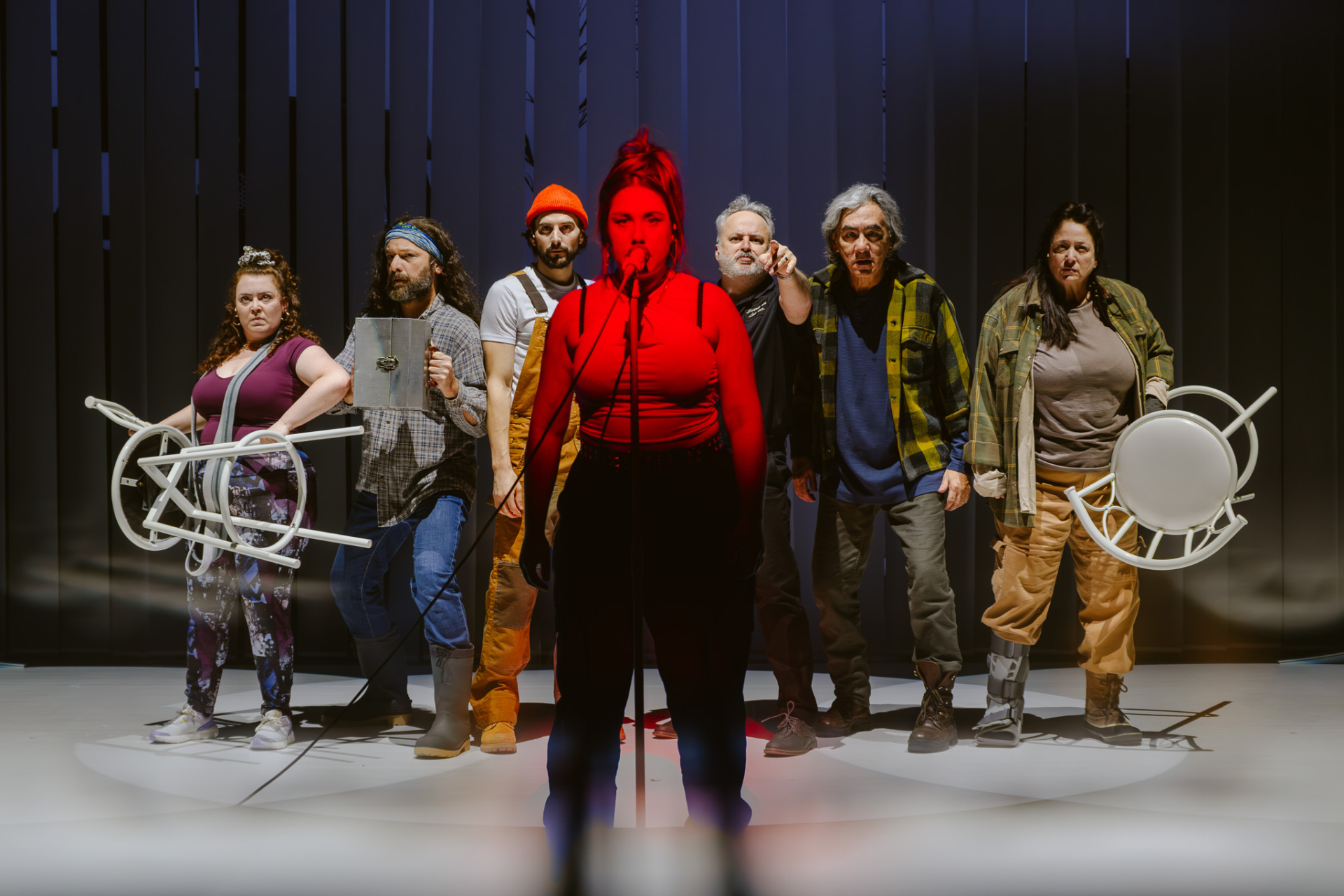 Several characters from the novel Querelle de Roberval are gathered behind Jezabel, illuminated in red, and express their discontent by holding objects.