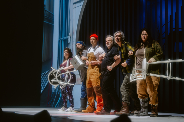 Several characters from the novel Querelle de Roberval are holding each other's arms and expressing their discontent, some with chairs in their hands.