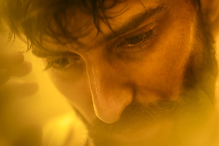 Un personnage sous une lumière jaune a l'air pensif