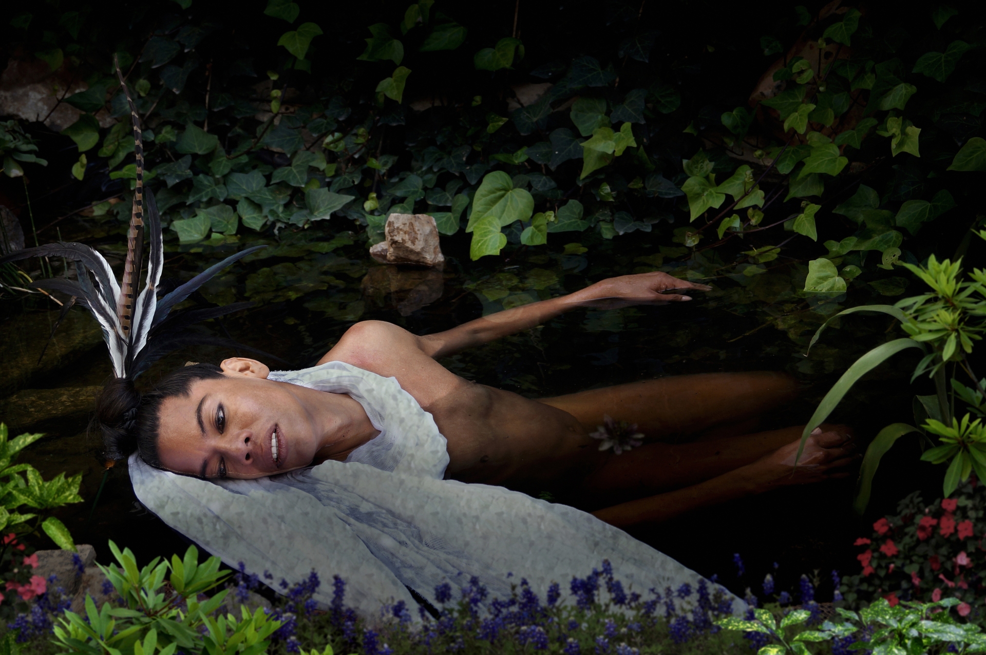 Lukas Avendano est étendu, dénudé, au milieu de végétaux luxuriants, avec un tissu blanc sous son visage.