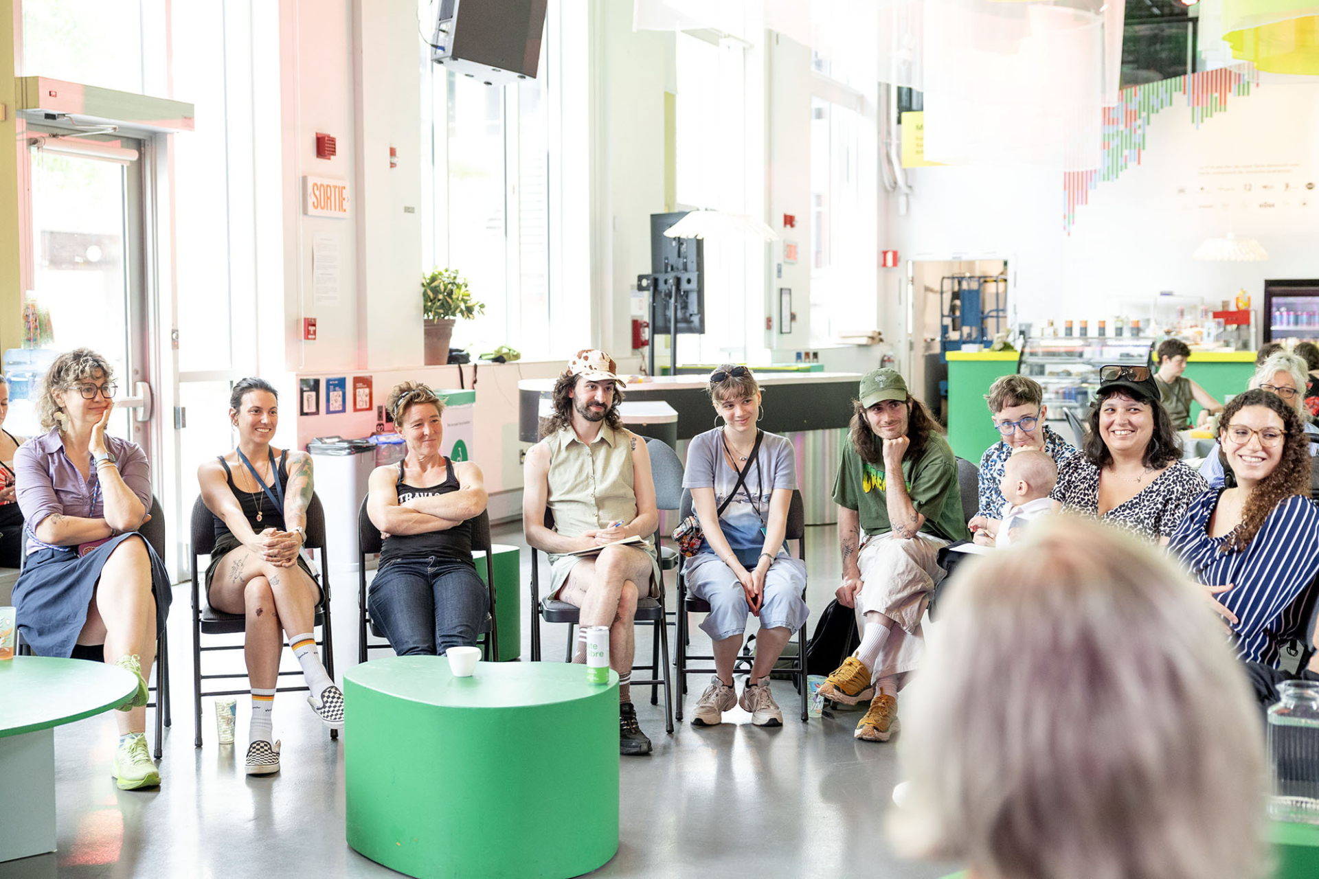 Plusieurs personnes sont assise en cercle et écoute une autre que l'on ne voit pas sur l'image.