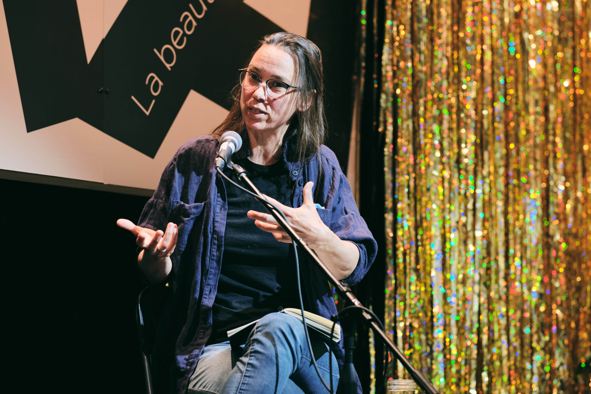 L’essayiste Dalie Giroux parle sur scène devant un micro lors d'un terrain de jeu organisé par le FTA.