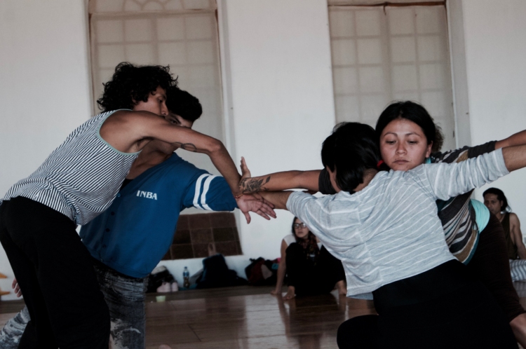 4 personnes dansent en entrant en contact les uns avec les autres, par les mains ou le buste.