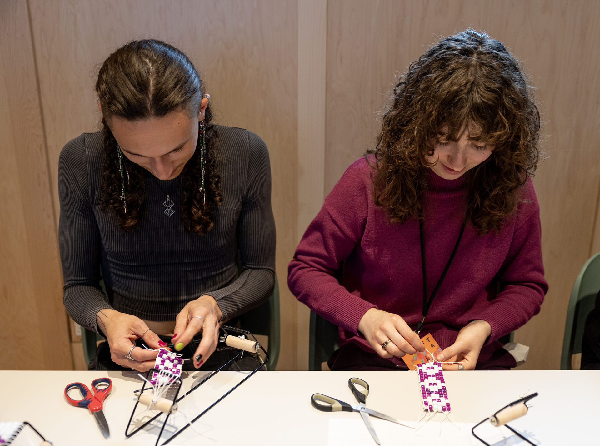 Two young people from the Eka Shakuelem program are doing a beading workshop.