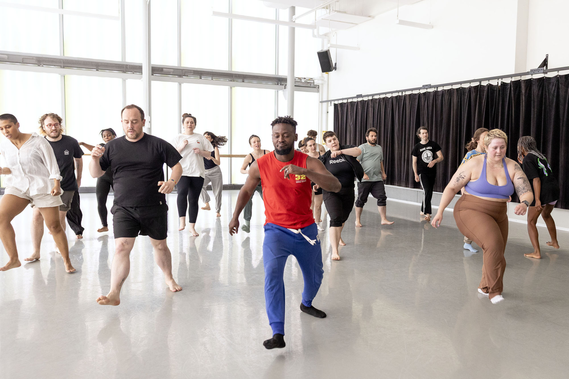 A group of people following the instructions of artist Dorothée Munyaneza during a workshop as part of the seminar rencontres internationales